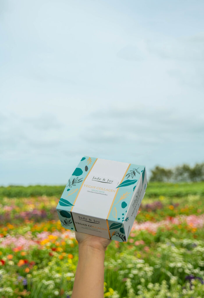 Jade & Joy Vegan Collagen Protein Bars in a flower field