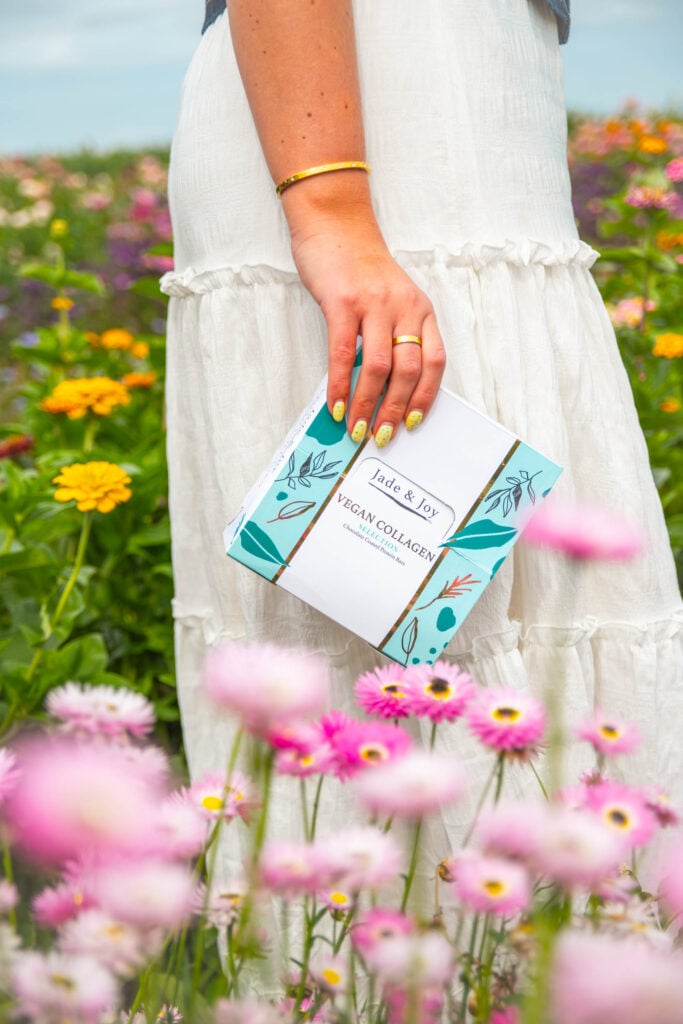 Jade & Joy Vegan Collagen Protein Bars in a flower field