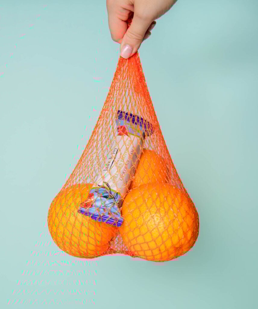 Jade & Joy Chocolate Orange collagen protein bar in a net of fresh oranges